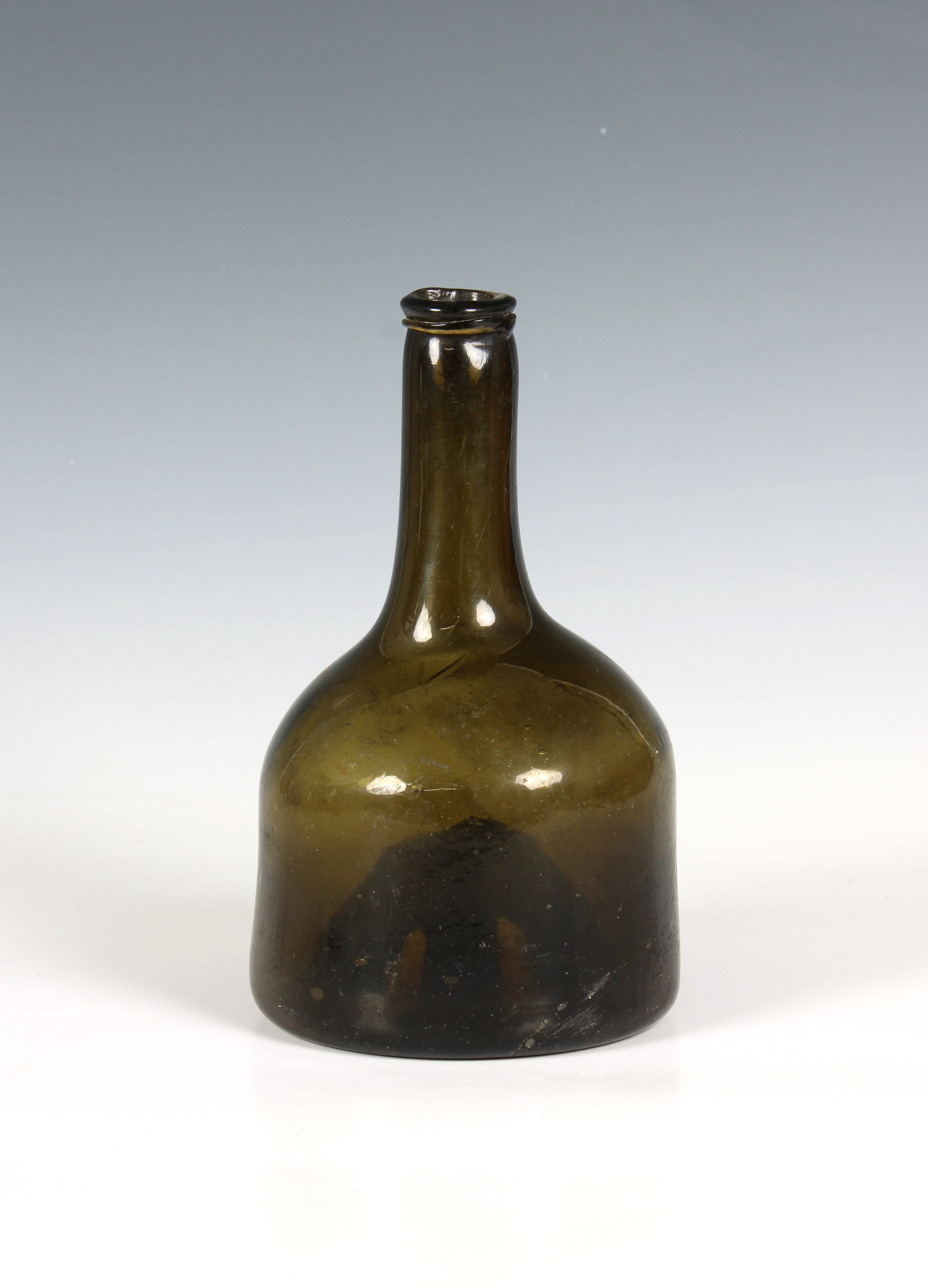 A green glass wine bottle of mallet form with trailed string rim probably mid 18th century, dark