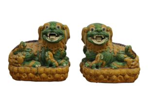 A near matching pair of 20th Century Chinese sancai yellow and green glazed figures of temple