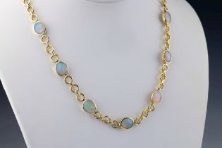 An 18ct yellow gold and opal necklace the cable chain set with thirteen oval cabochon opals in