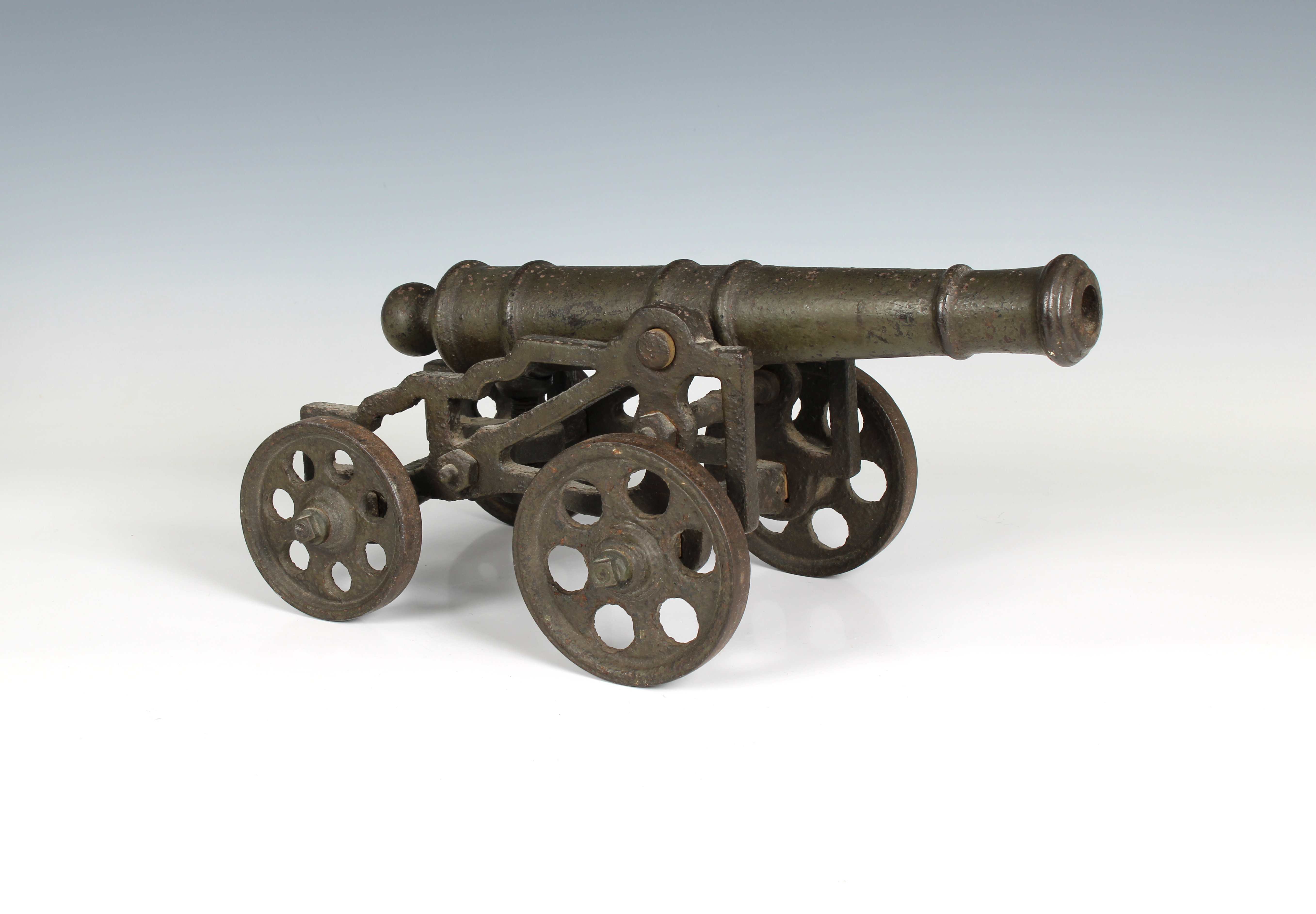 A model cannon with an iron barrel and iron four wheeled gun carriage