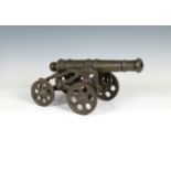 A model cannon with an iron barrel and iron four wheeled gun carriage