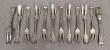 A set of Eleven George IV silver fiddle pattern dinner forks, together with a matched William IV sil