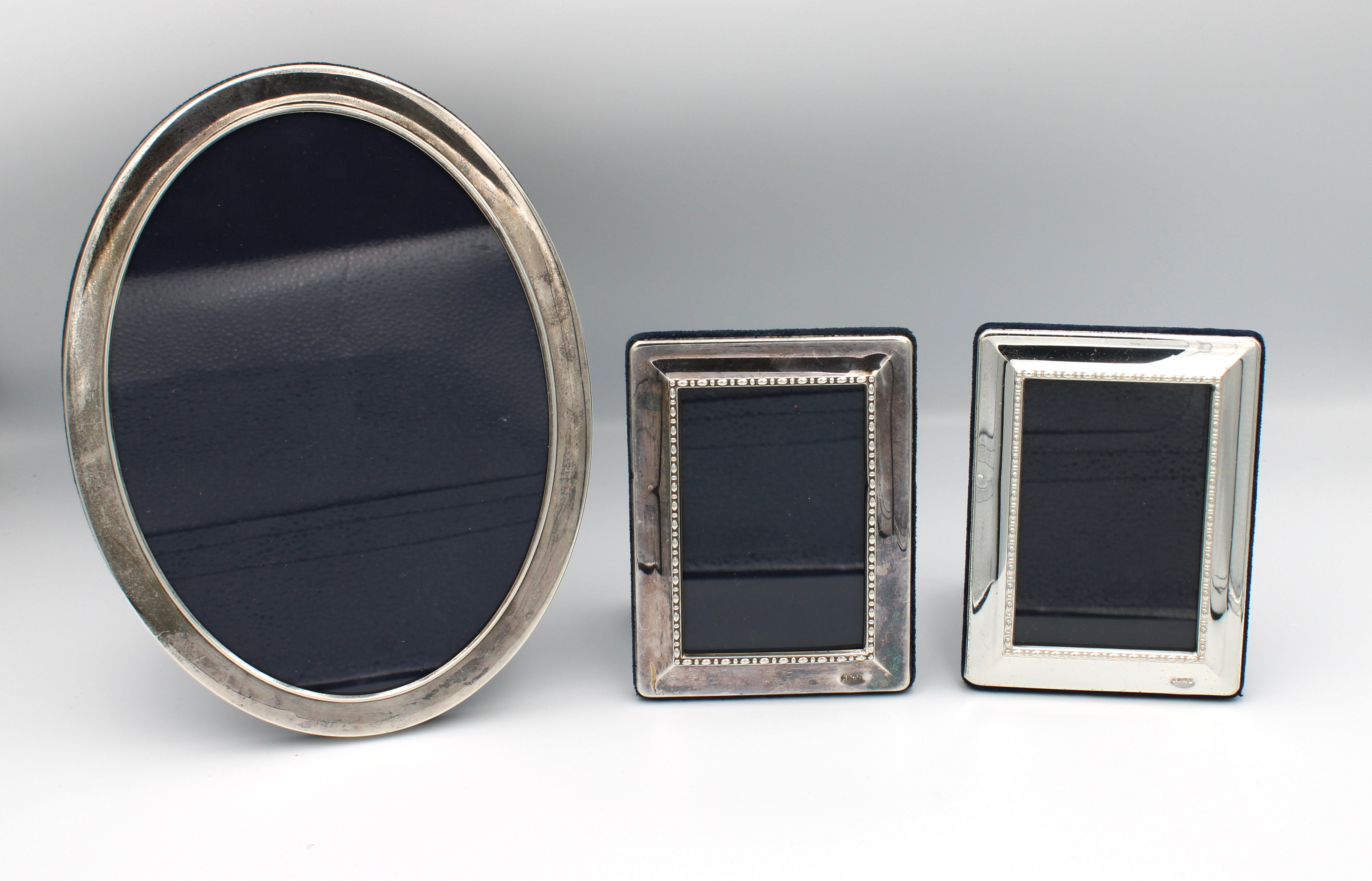 Three silver easel back photo frames