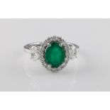 An emerald and diamond cluster ring