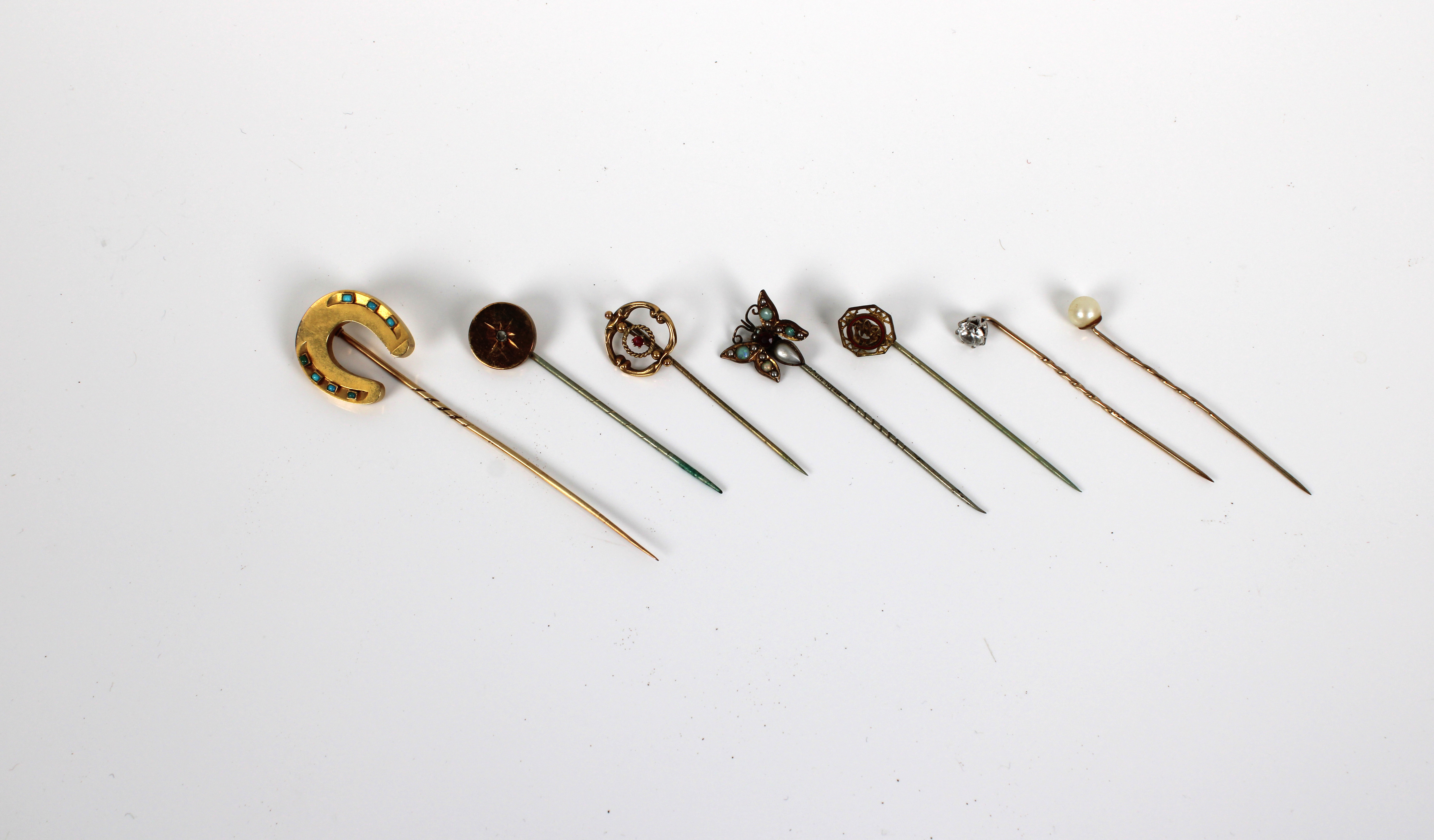 A small collection of yellow metal hat/tie pins