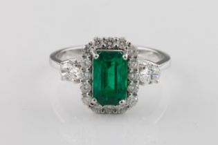 An emerald and diamond cluster ring