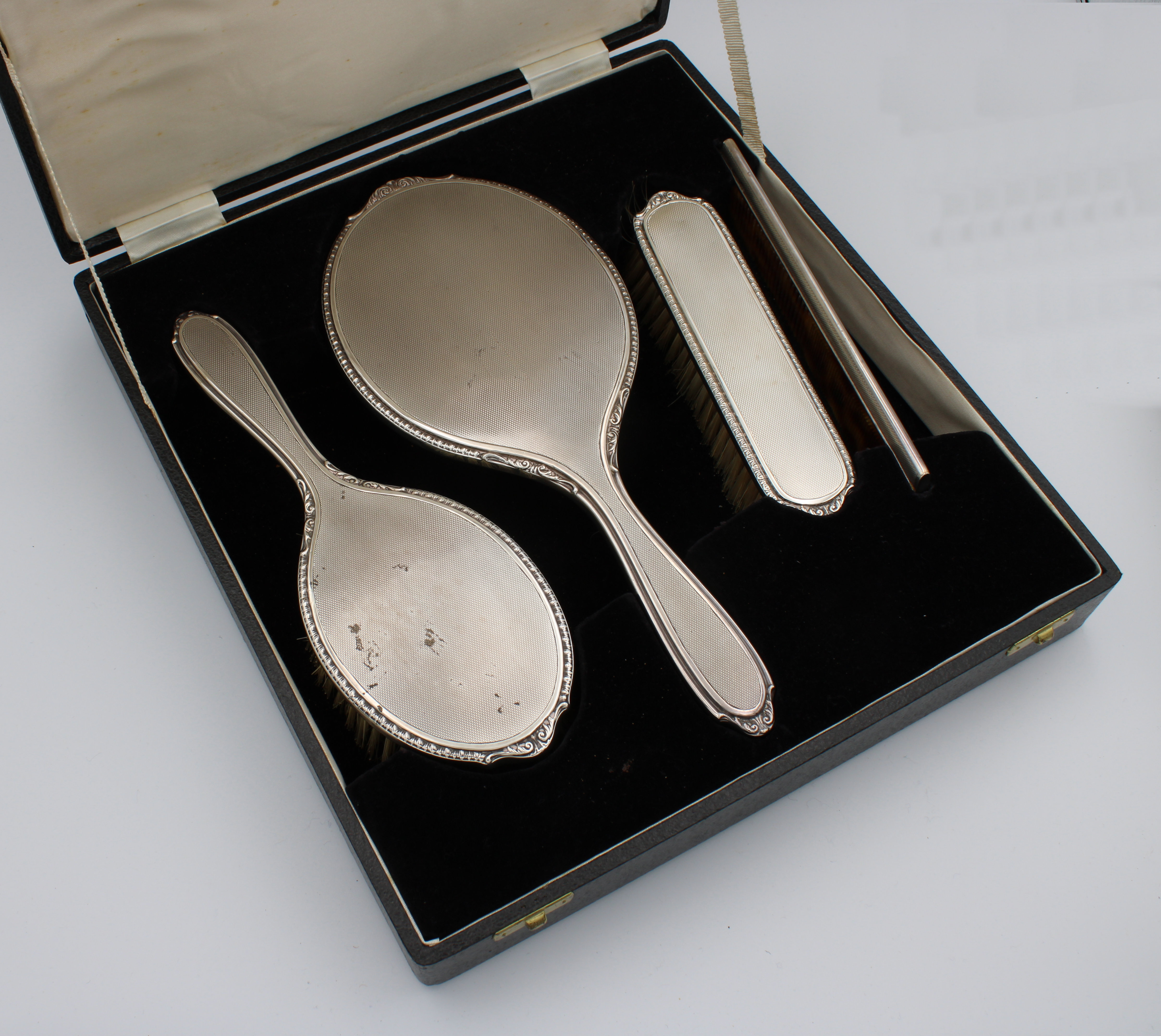 An Elizabeth II cased four piece silver dressing table set