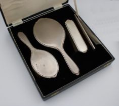 An Elizabeth II cased four piece silver dressing table set