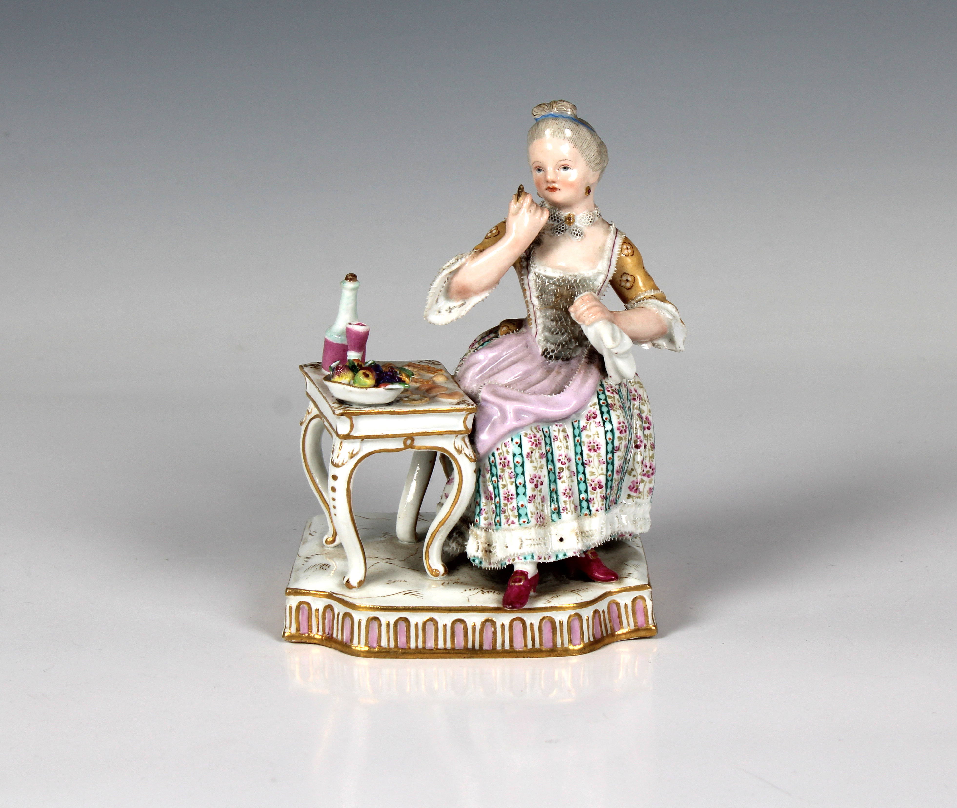 A Meissen porcelain figure of a seated lady taking tea