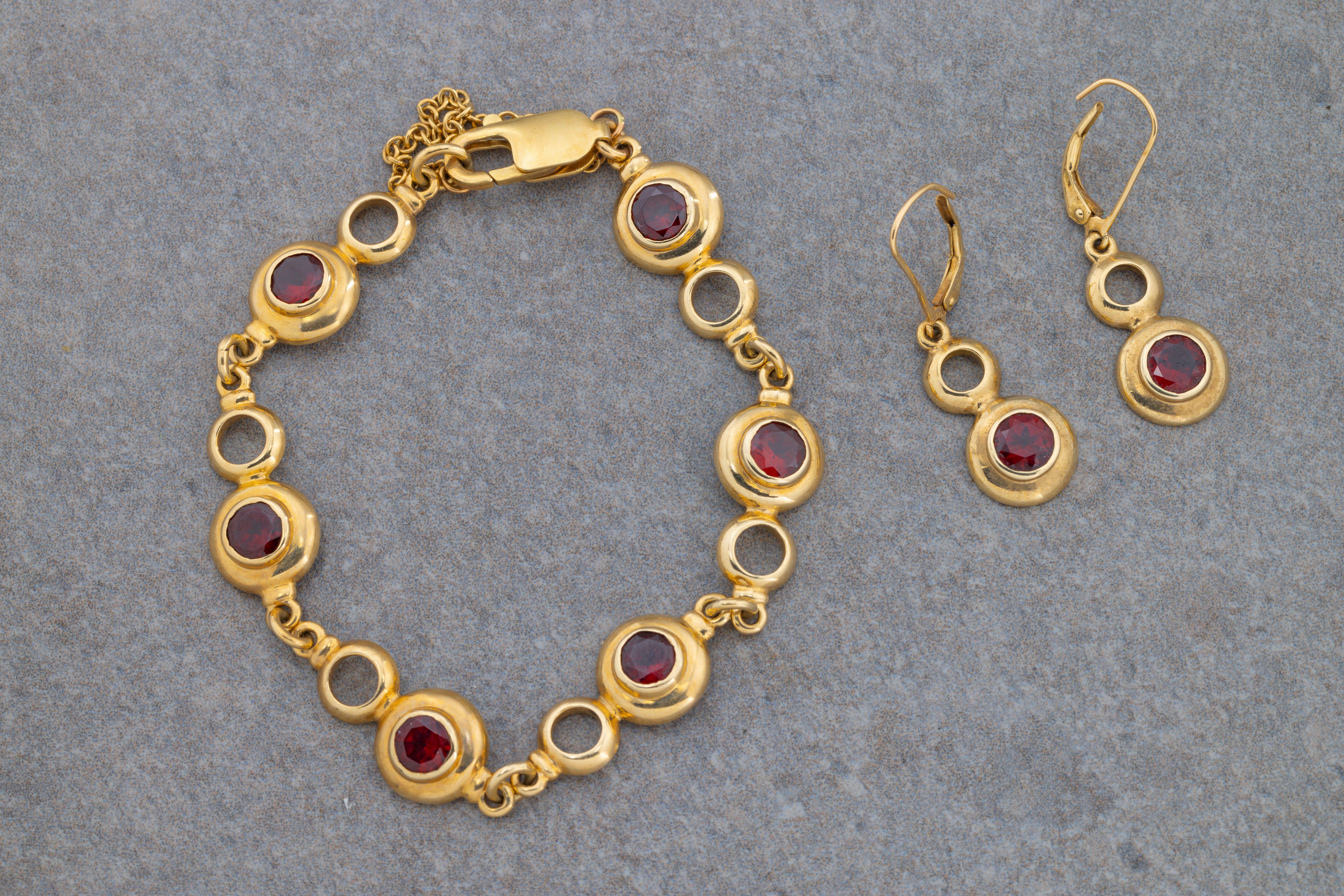 A 9ct yellow gold and garnet bracelet and matching earrings