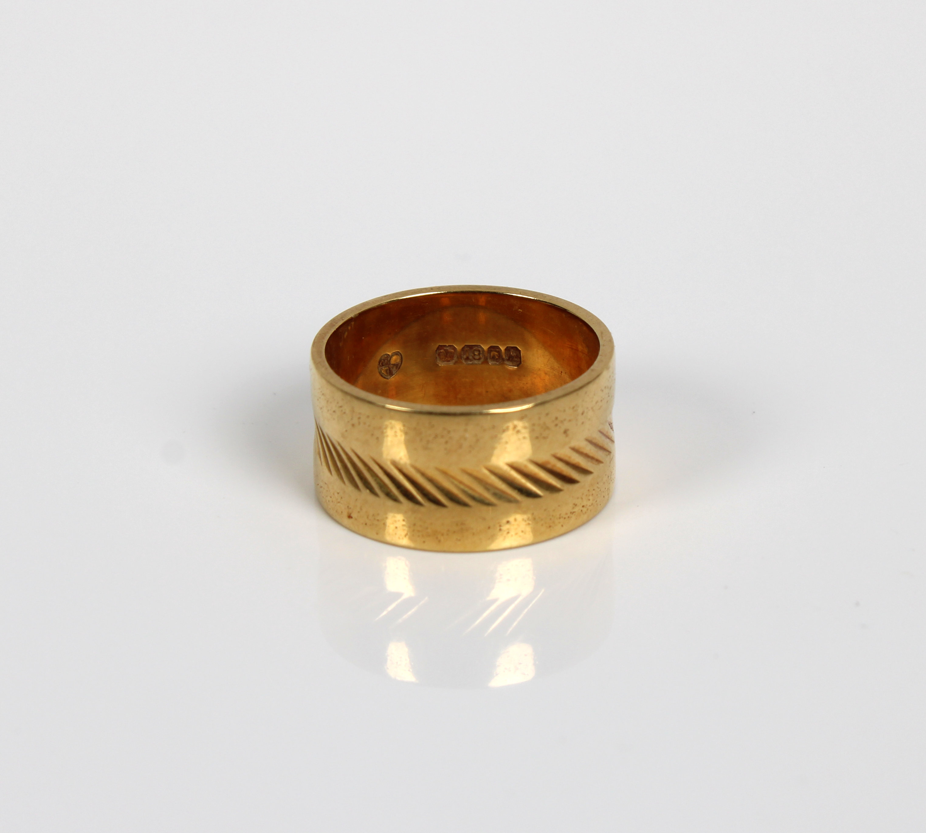 An 18ct gold ring with central tooled band