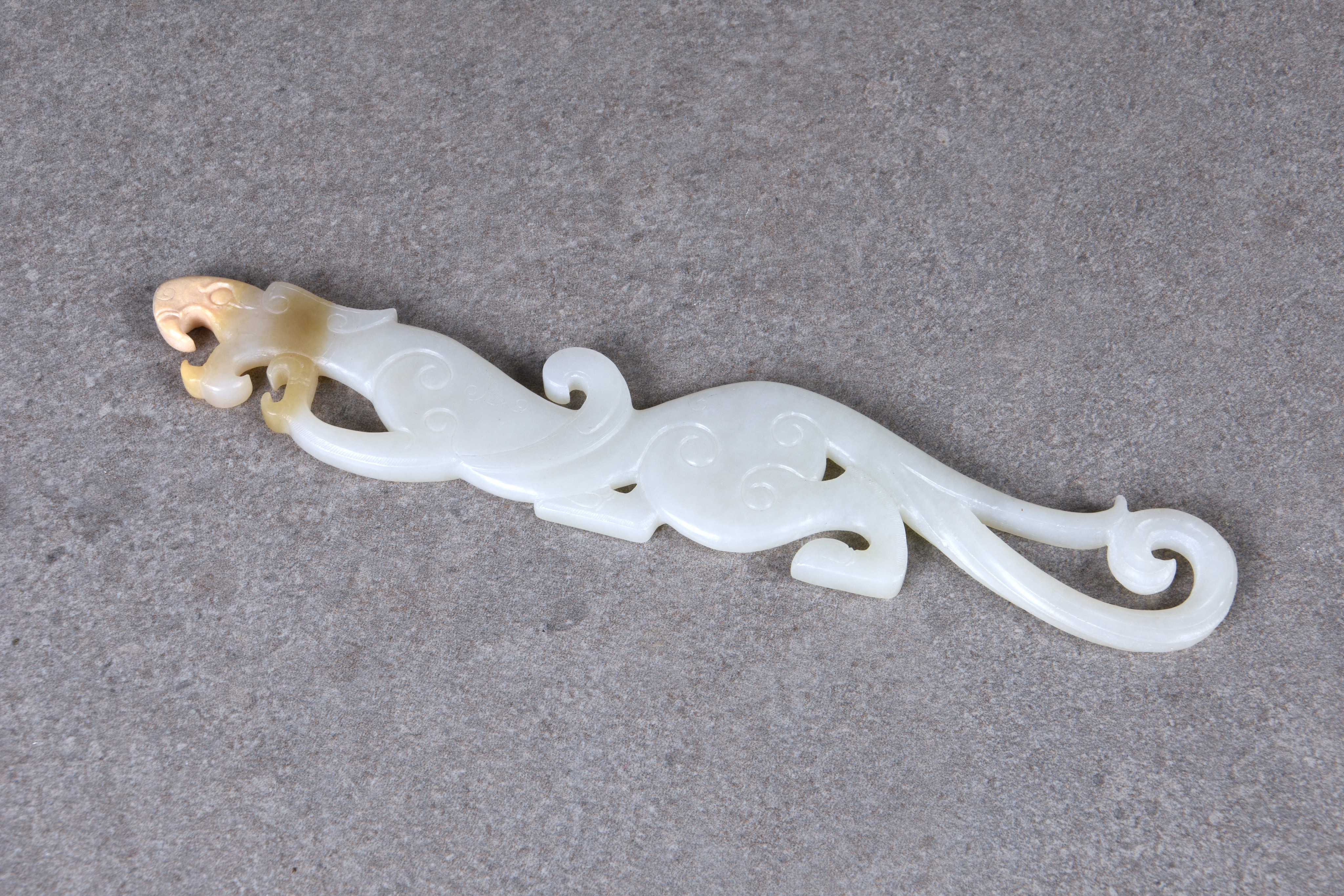 A Chinese white and pale russet jade dragon pendant plaque