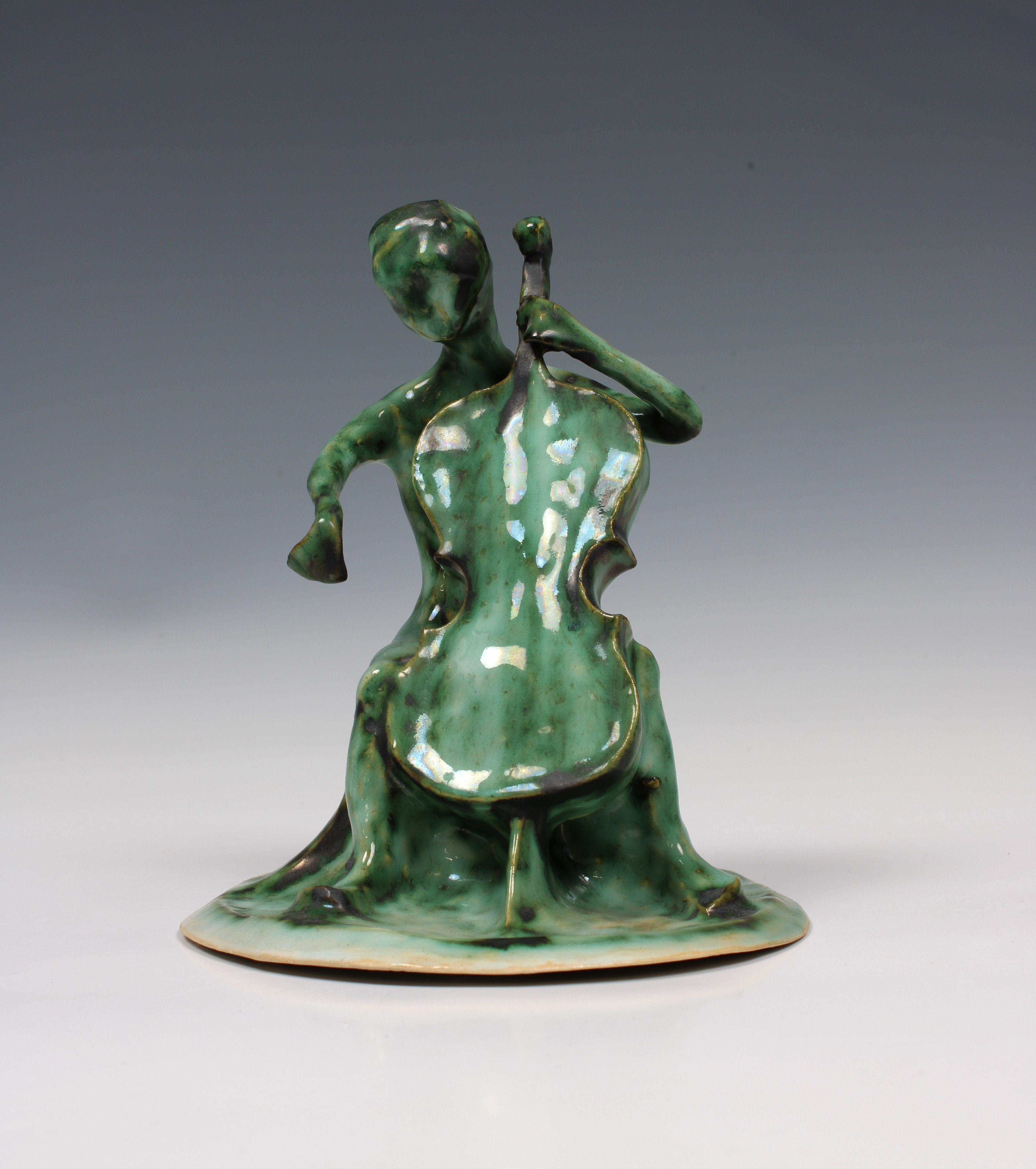 Elizabeth Ann Macphail (1939-89) A green glazed stylised cellist or double bass player sculpture