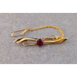 A 9ct gold bar brooch inset with a single red glass stone