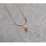 A 9ct gold necklace featuring a decorative loop set with three diamonds