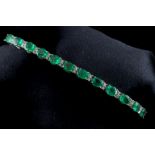 An 18ct white gold emerald and diamond line bracelet