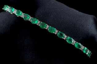 An 18ct white gold emerald and diamond line bracelet