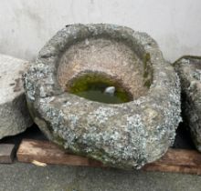 A weathered oval granite trough