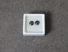A pair of loose, round cut blue sapphire