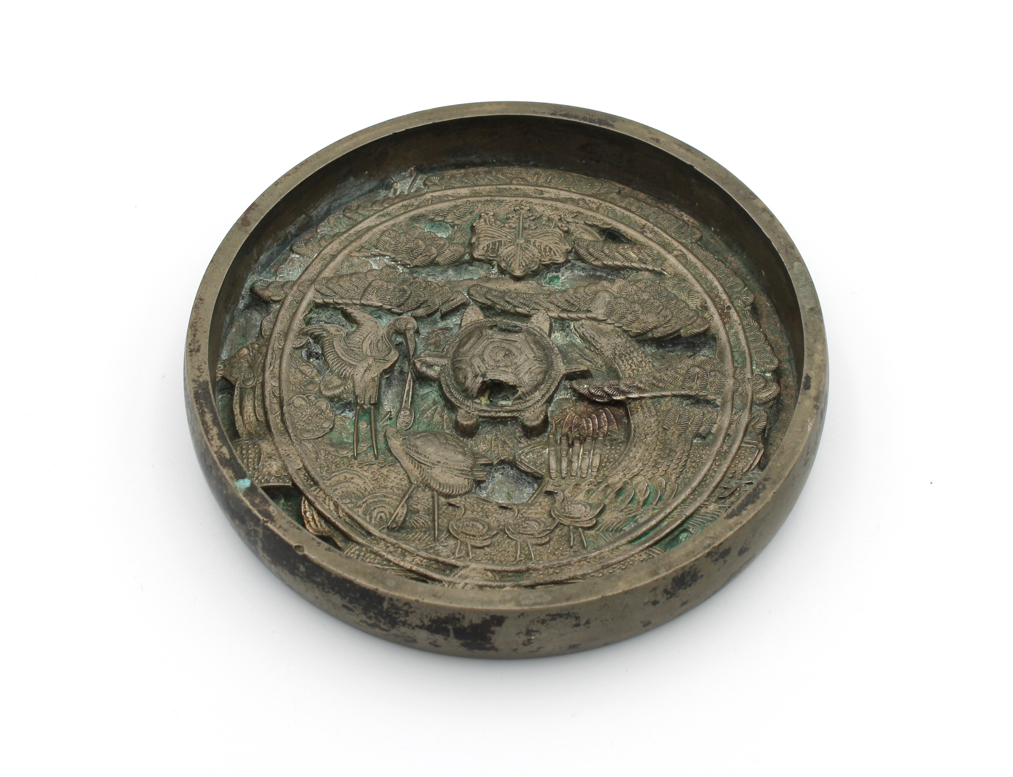 A Chinese bronze mirror profusely decorated to one side