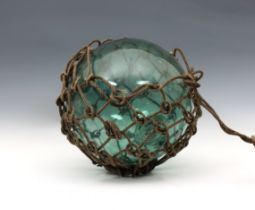 A large 19th century blown glass light green fishing float