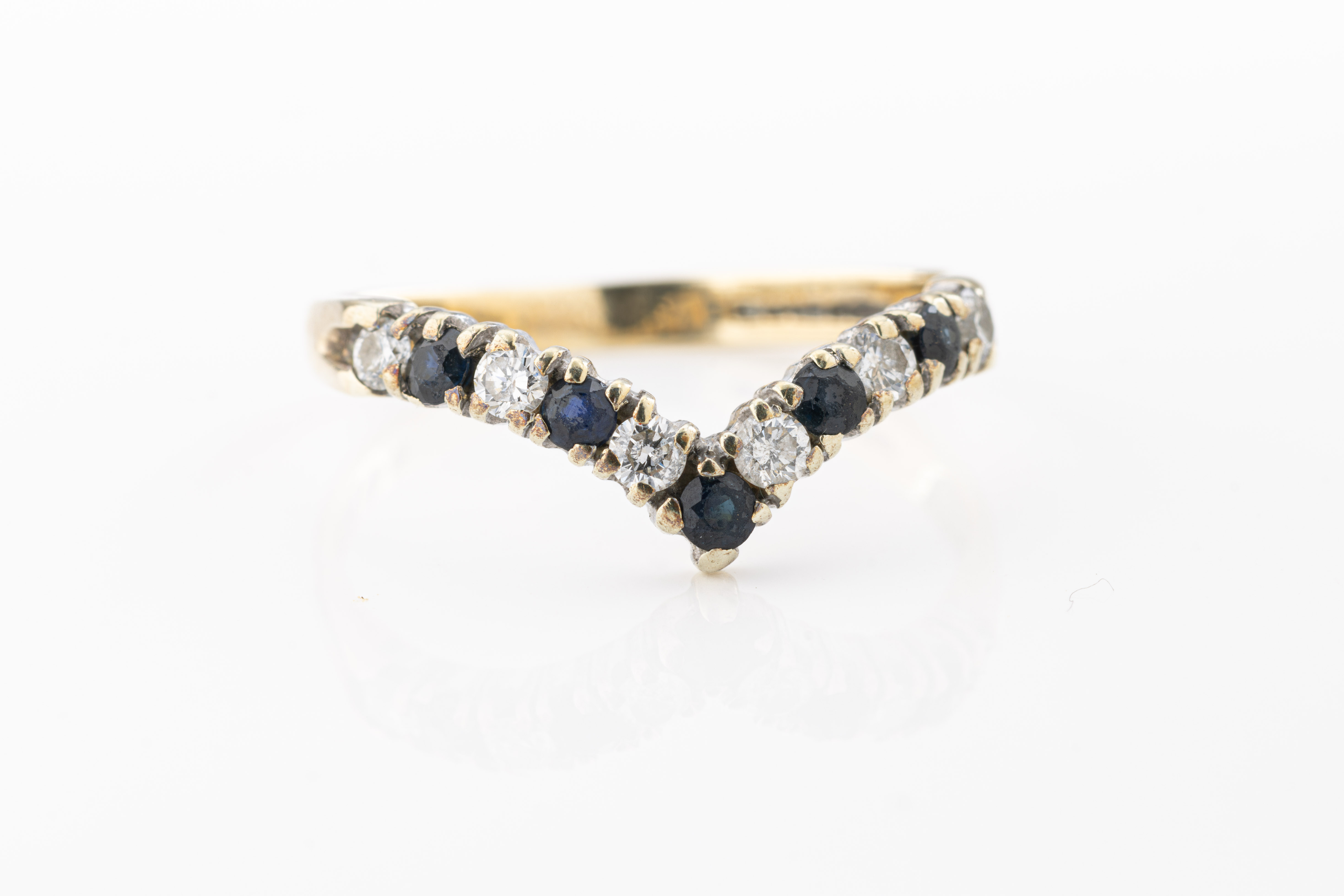 A yellow gold sapphire and diamond "V" shaped ring