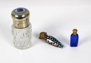 A cut glass scent bottle with white metal mount inset with an enamelled Guernsey doubles coin