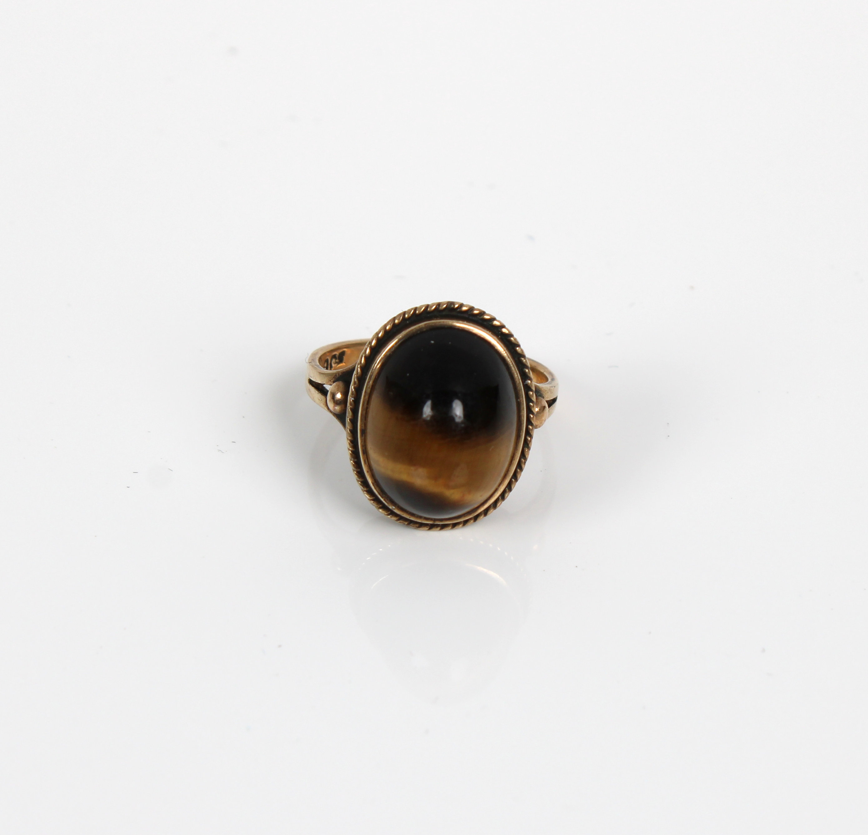 A 9ct gold ring inset with a polished Tigers Eye cabochon
