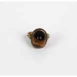 A 9ct gold ring inset with a polished Tigers Eye cabochon