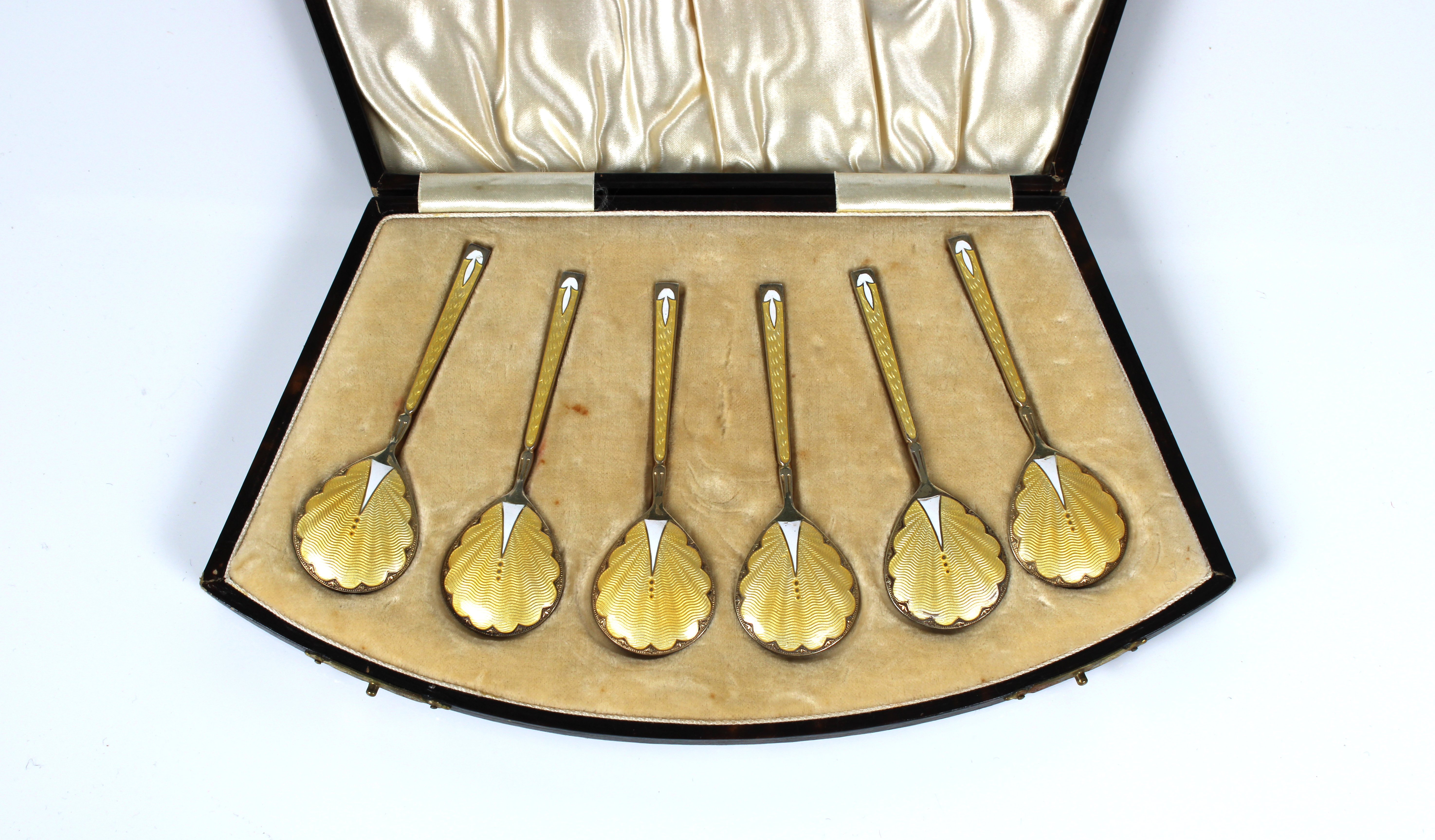 A cased set of six Art Deco silver gilt yellow & white guilloche enamel caviar / demitasse spoons