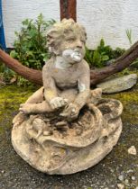 A 20th century composite stone garden figure of a cherub