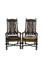 A pair of 19th century Carolean style carved wooden open armchairs