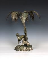 A silver plated centrepiece in the form of two greyhounds sheltering beneath palm trees