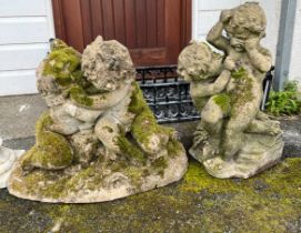 Two composite stone garden statues of cavorting cherubs