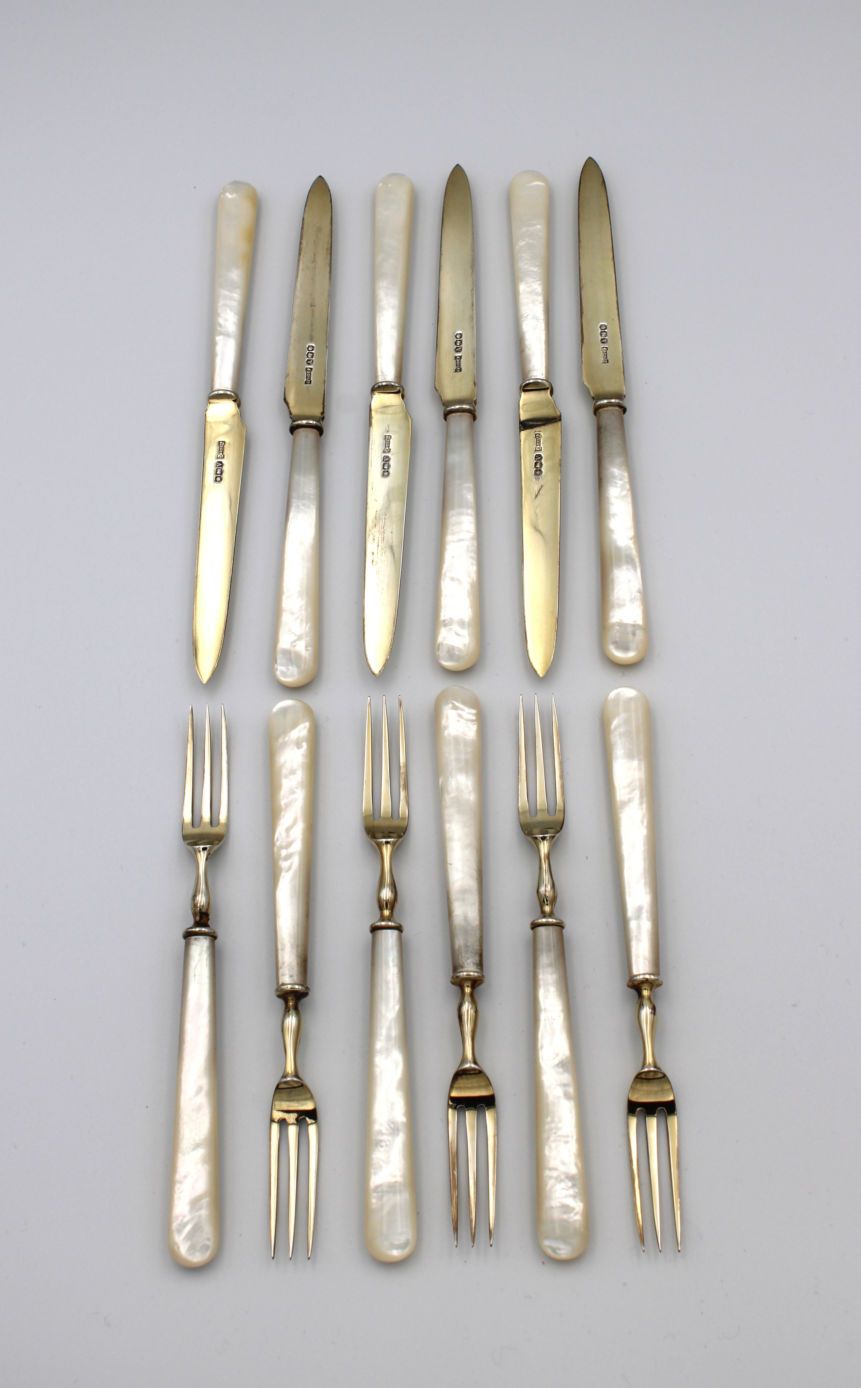 A set of six Asprey silver-gilt fruit knives and forks with mother-of-pearl handles