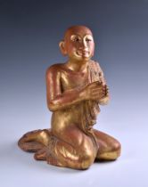 A Burmese Mandalay carved and jewelled gilt wood figure of a seated monk