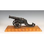 A model cannon with an iron barrel and iron two wheeled gun carriage