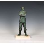 A French patinated bronze figure of a fireman with a silvered bronze helmet