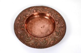 An Arts & Crafts hand beaten copper bowl of stylised ivy leaf design