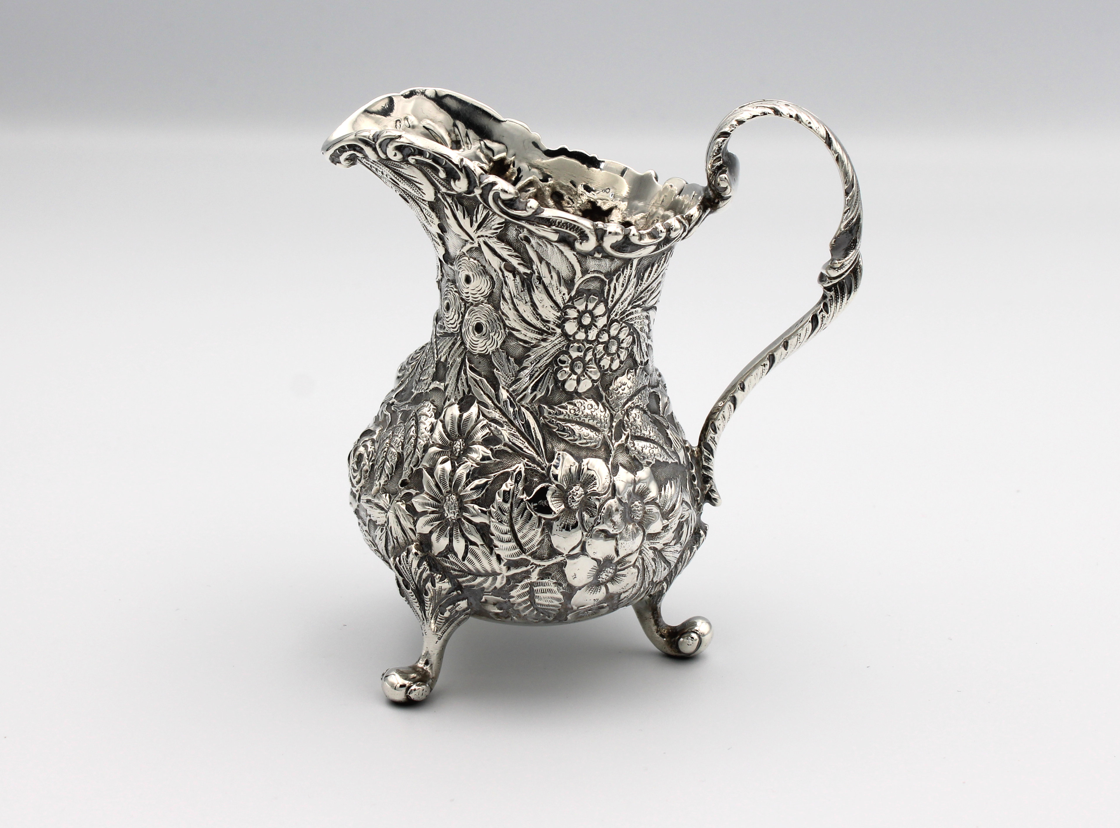 A silver milk jug heavily chased with flora - Image 2 of 4