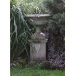 A Composite tazza form urn raised on a stepped plinth