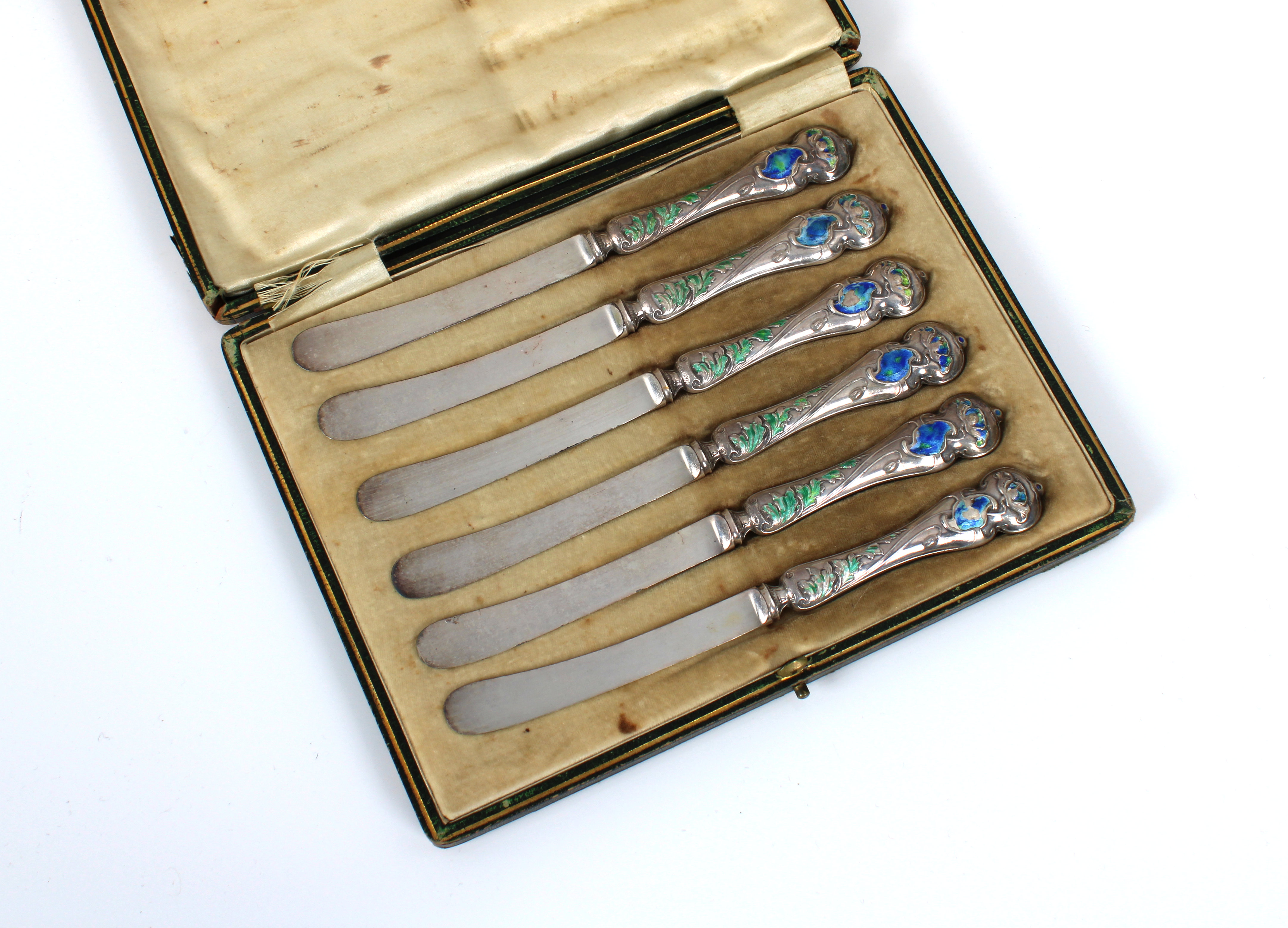 A set of six Art Nouveau silver handled butter knives decorated with blue and green enamel