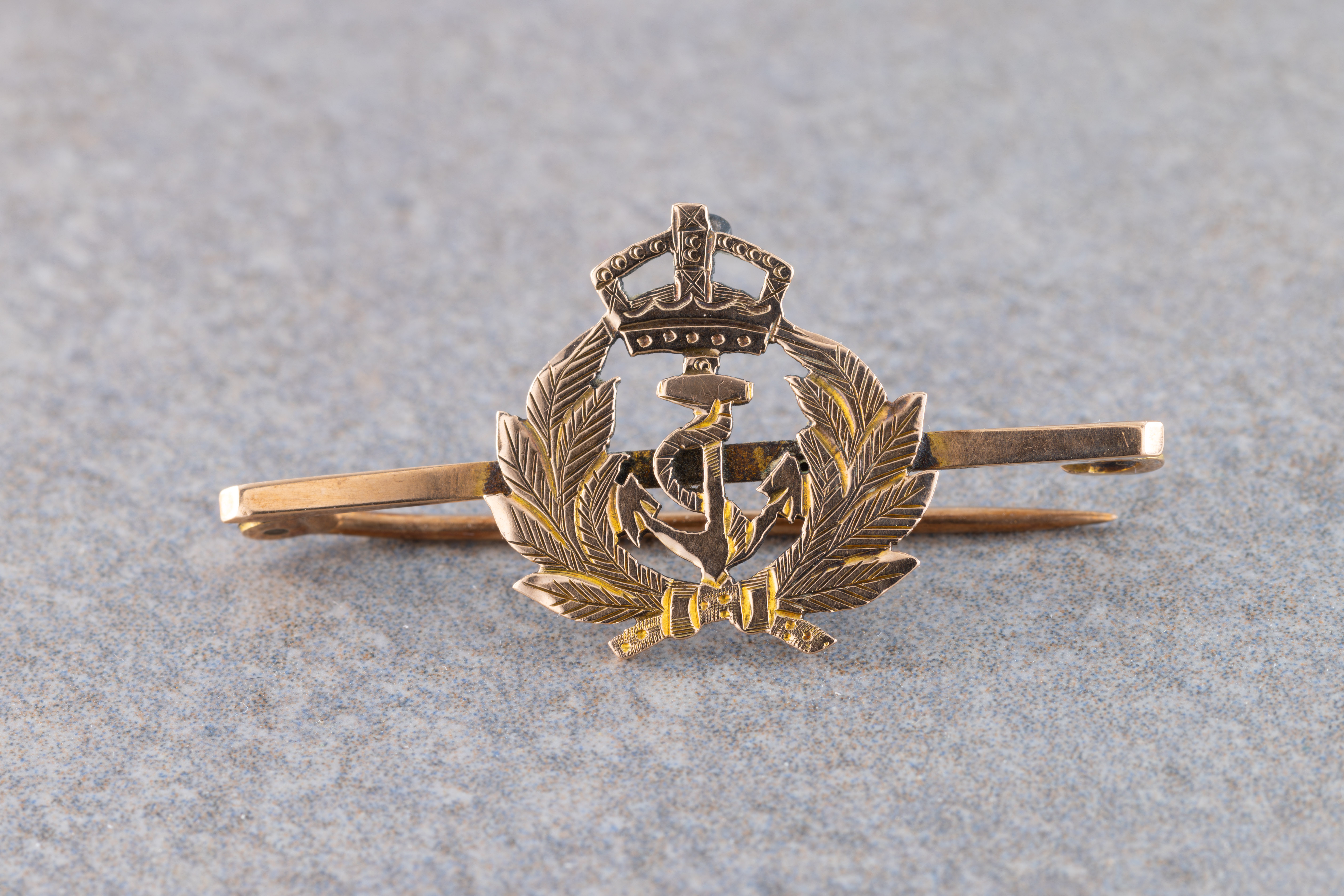 A 9ct gold Royal Navy bar brooch of a crown, anchor and laurel design