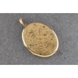 A 9ct gold oval pendant locket with scrolling bright cut decoration