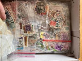 Shoebox crammed with used stamps sorted in bags (1000's)