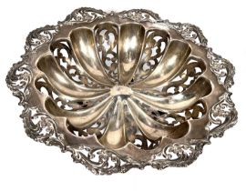 A hallmarked silver circular dish, ribbed and pierced with floral border, on 4 ball feet,