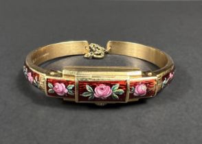 A ladies yellow metal bangle/watch, stamped '750', with red ground floral enamel decoration and