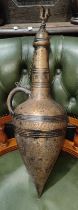 An antique brass amphora etched with script around body