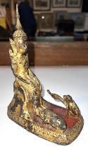 A Tibetan style buddha in gilt sitting with elephant and monkey, ht. 16cm