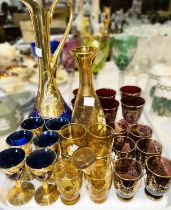 Two Venetian coloured glass liqueur sets with gilded and floral decoration; a selection of